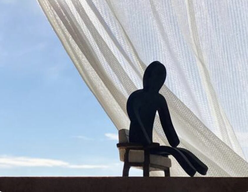 うなだれて座る黒い人形